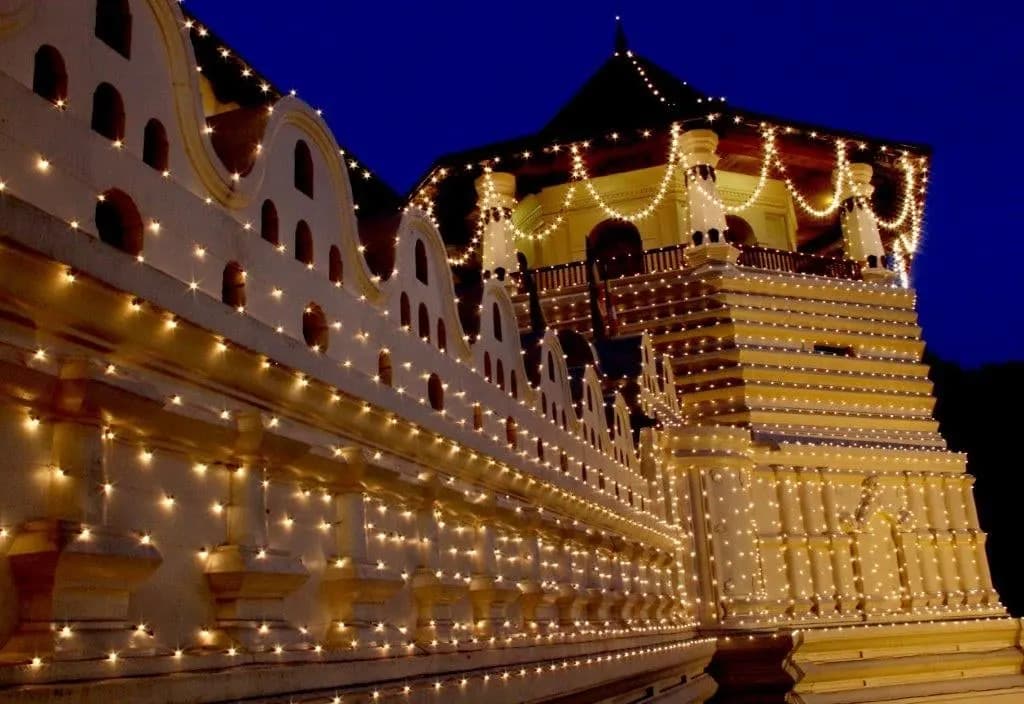 The Temple of the Tooth outlined in lights against a night sky