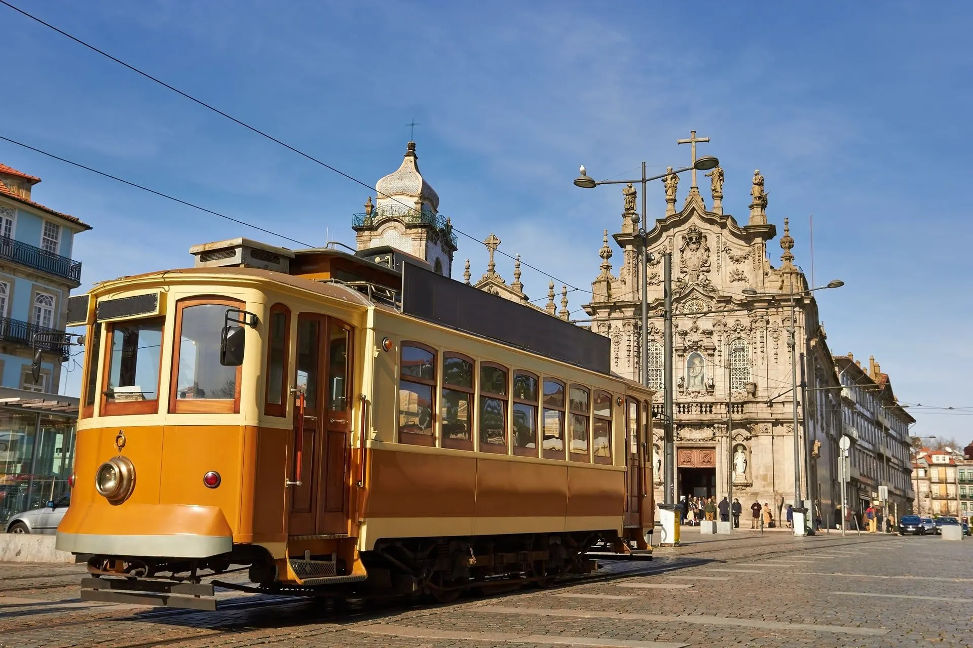 A vintage Porto tram in front of the baroque Carmo church