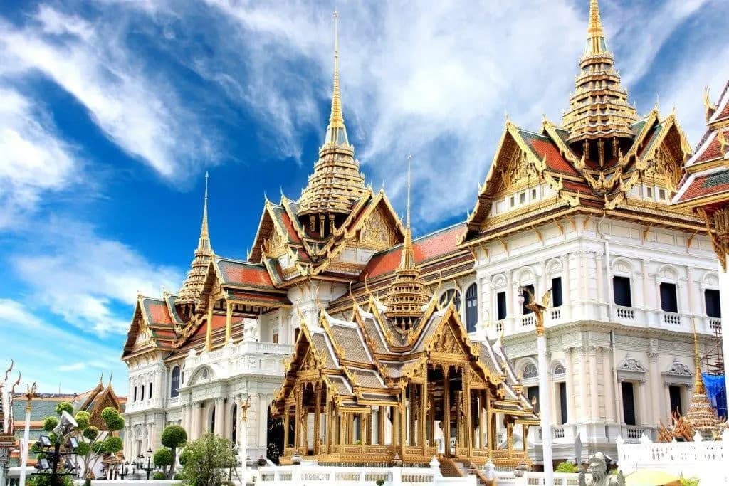A white and gold throne hall with tiered spires at the Grand Palace