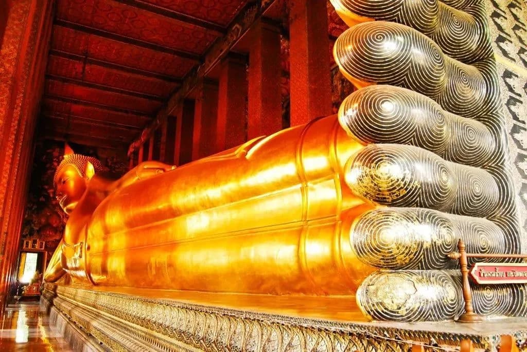 The full length of the golden reclining Buddha at Wat Pho, from its feet