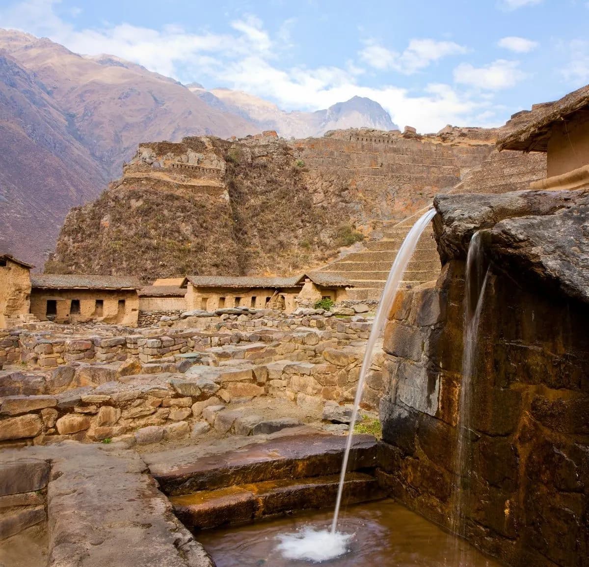 Water pouring from an Inca stone fountain below the Ollantaytambo terraces