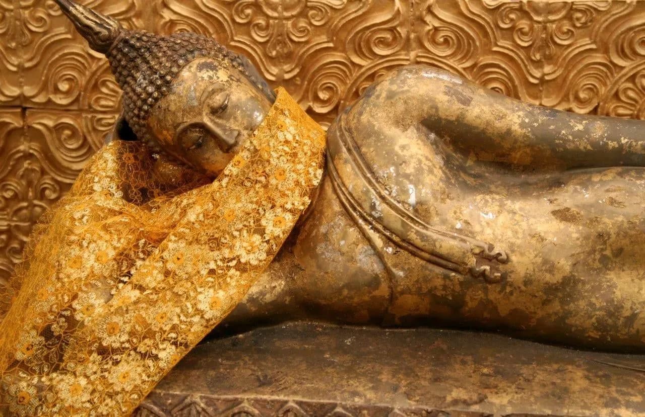 A gilded reclining Buddha draped in golden cloth