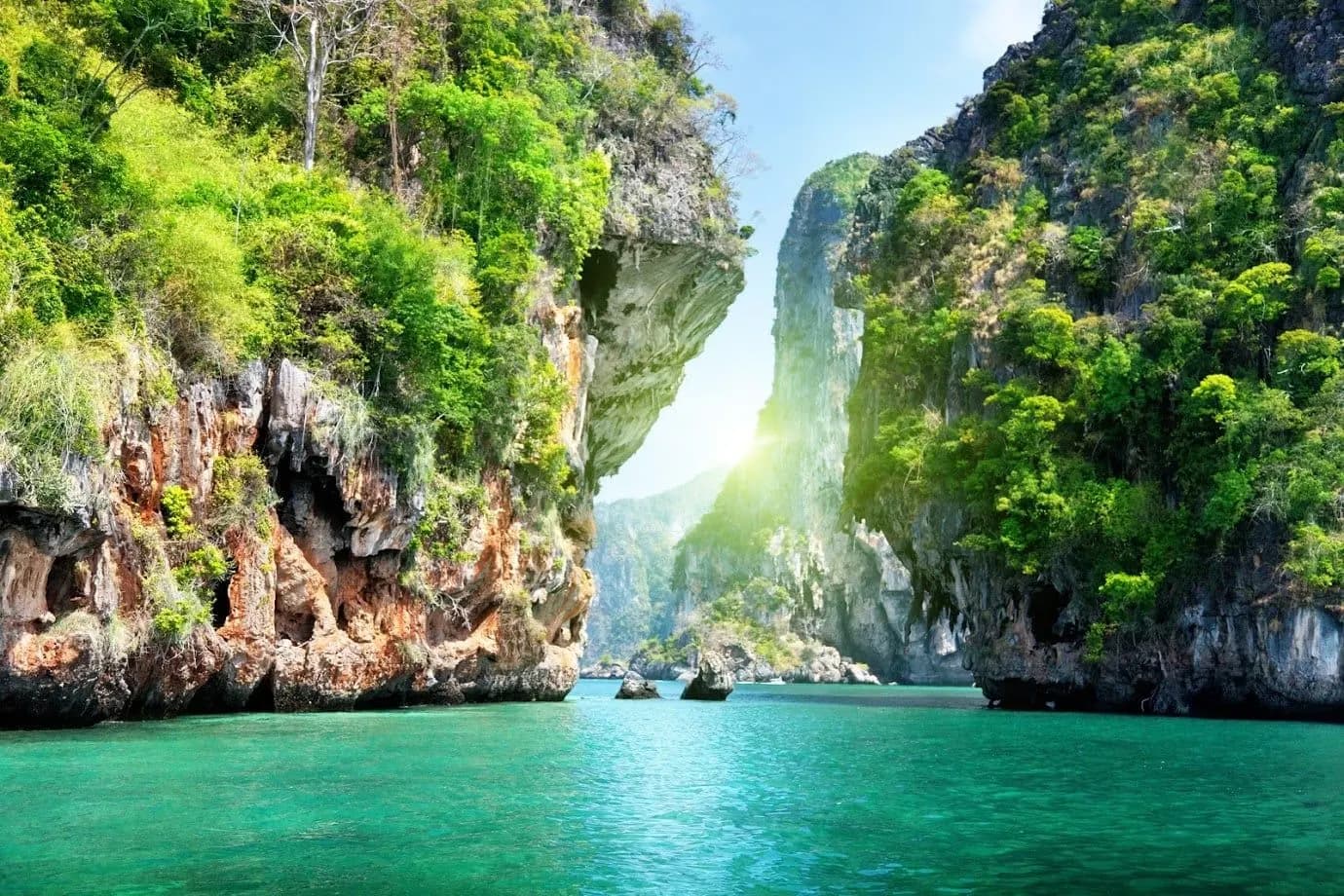 Jungle-covered limestone cliffs above an emerald channel of sea
