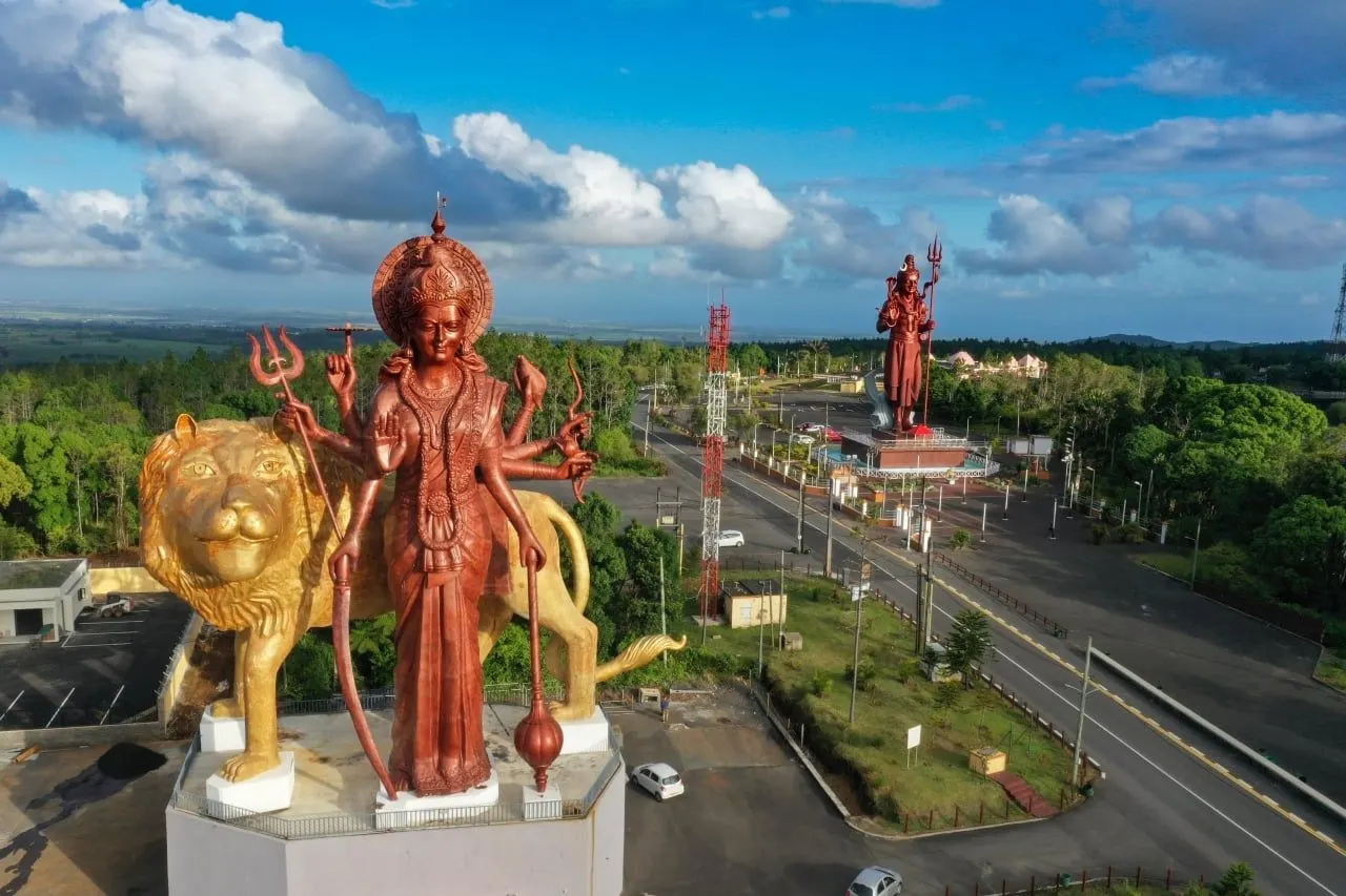 Tall statues of Hindu deities near Ganga Talao, the sacred lake in the island's interior