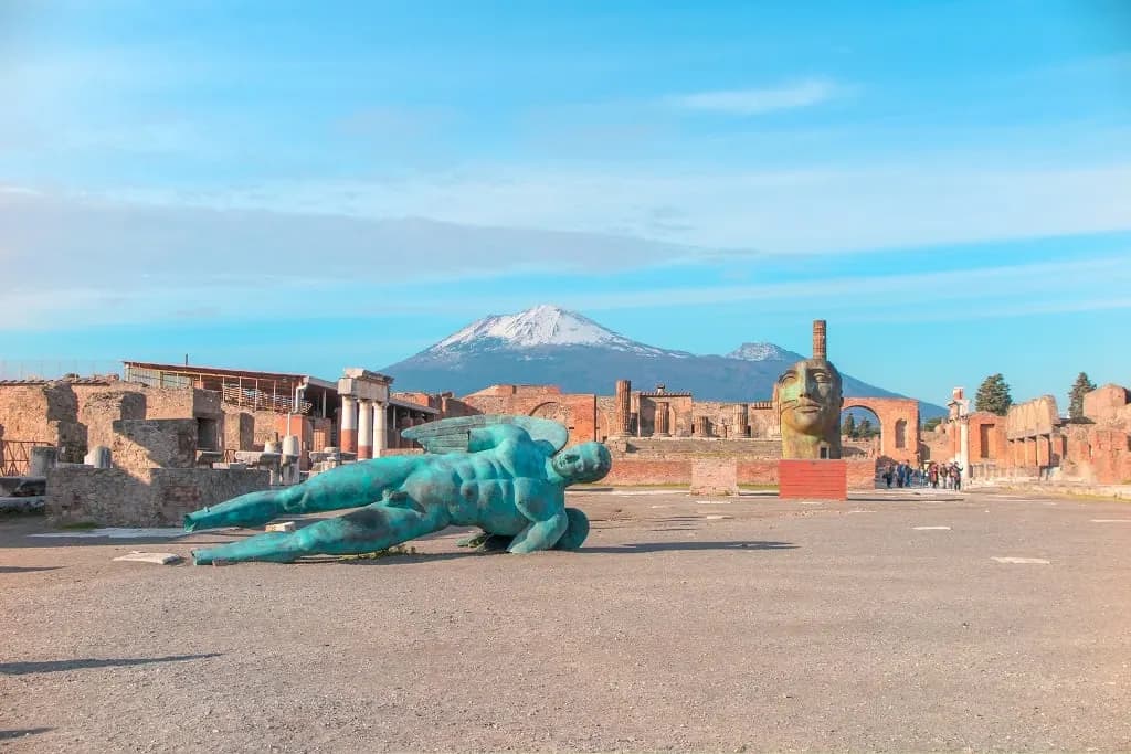 A bronze sculpture lying in the Pompeii forum, with Vesuvius in the distance