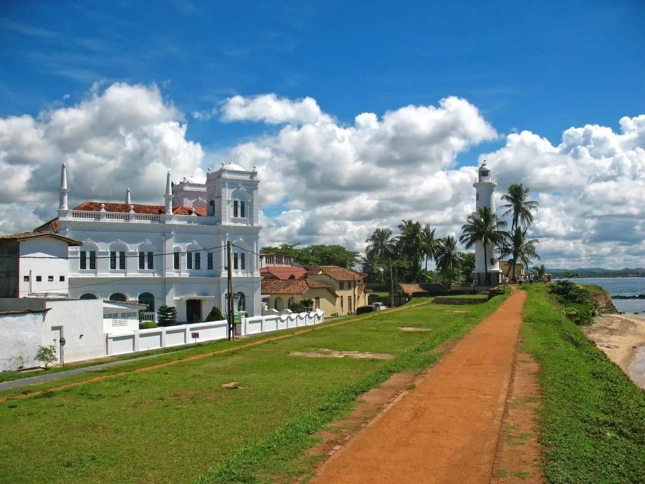 A grassy rampart path at Galle Fort leading to a white lighthouse