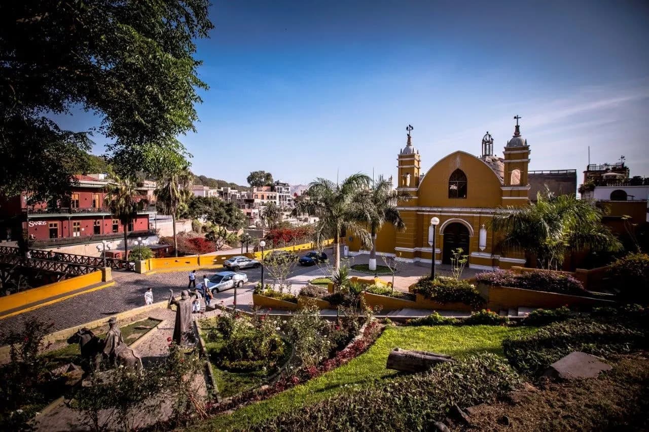 A yellow church and gardens beside a square in Barranco