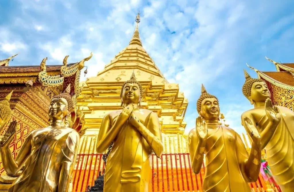 Golden Buddha statues in front of the gilded chedi of Wat Phra That Doi Suthep
