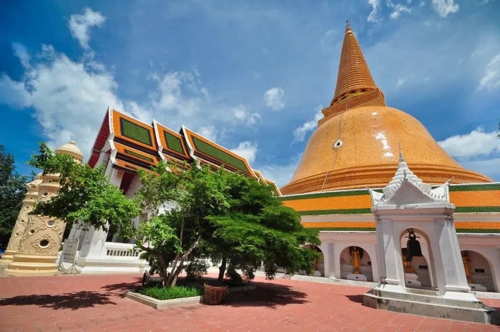 The orange-tiled dome of Phra Pathommachedi behind a temple courtyard