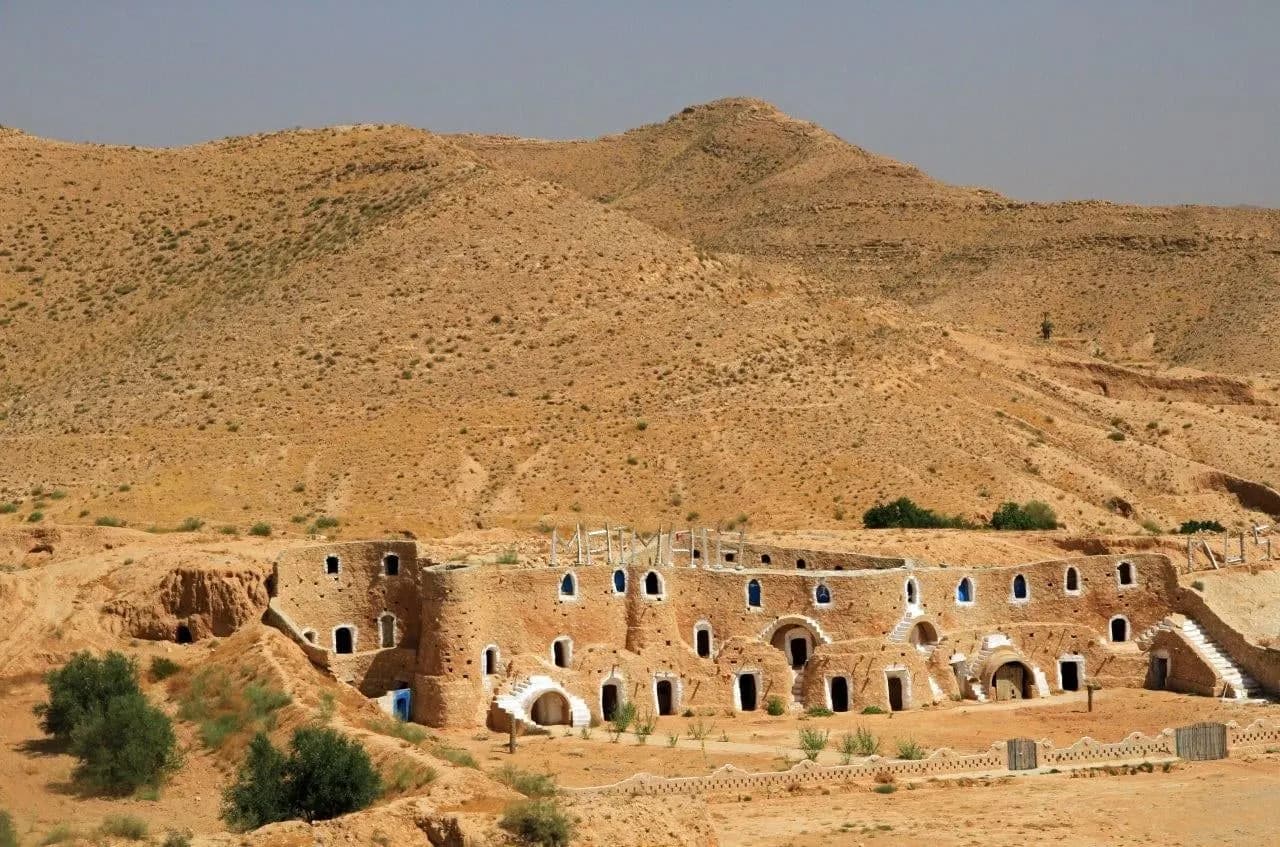 Old earthen dwellings set into a dry hillside in southern Tunisia