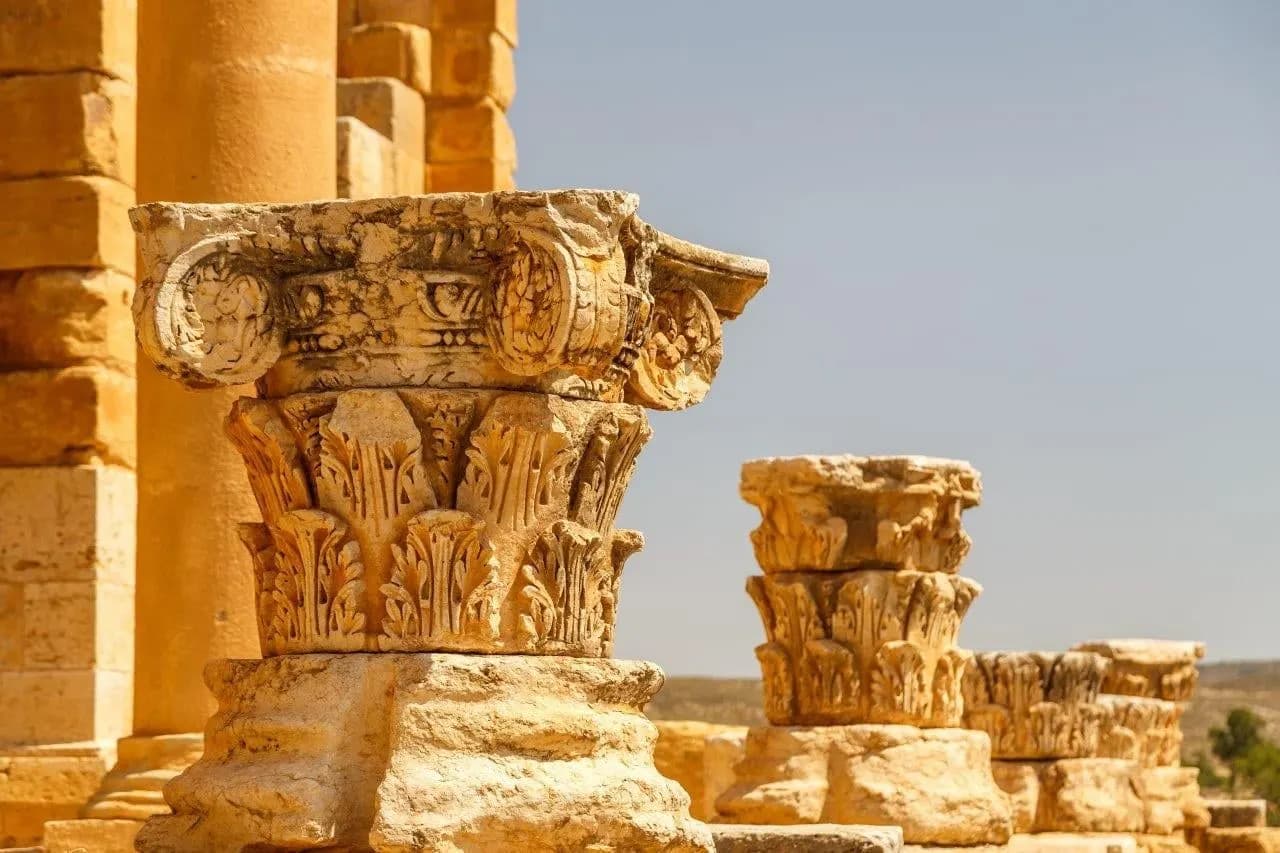 Carved Corinthian capitals on Roman columns in golden light