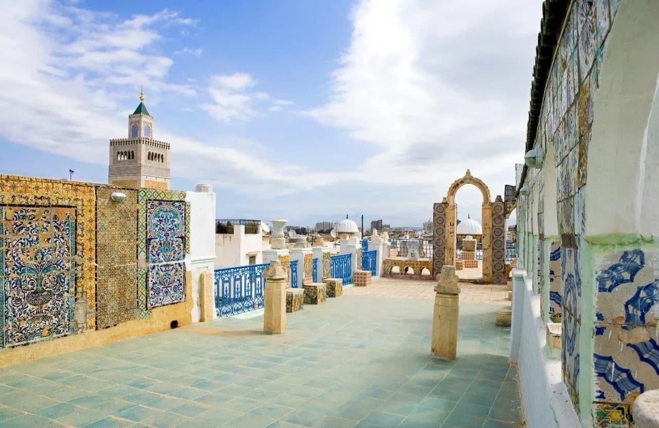 A tiled rooftop terrace with a minaret in the medina of Tunis