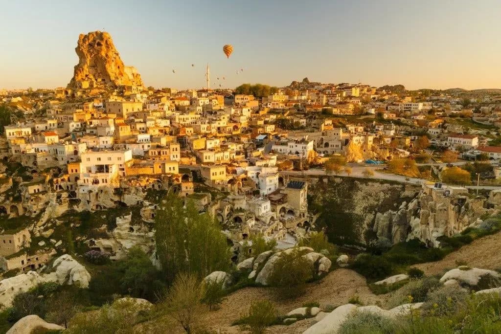 A rock citadel above a cave village in Cappadocia in golden evening light
