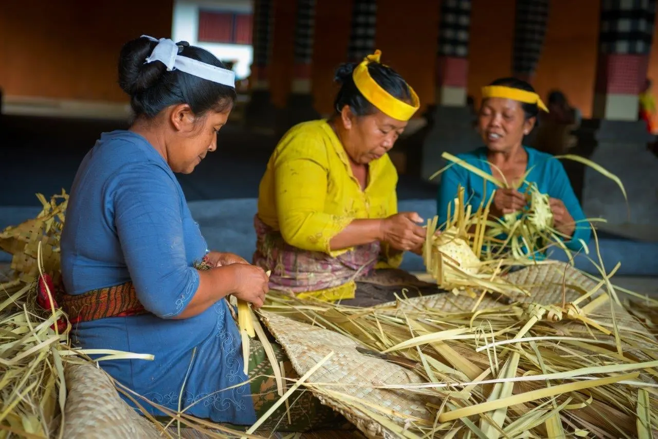 Balinese women weaving baskets and offerings from palm leaves
