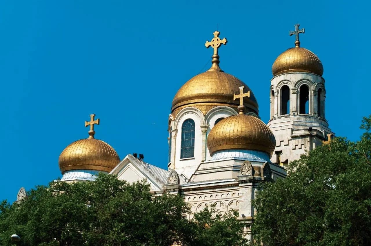 Gilded domes and crosses of the Varna cathedral against a deep blue sky