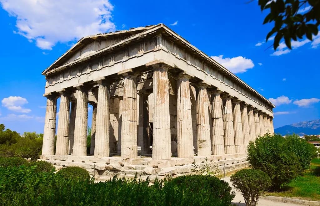 A well-preserved Doric temple among trees in Athens