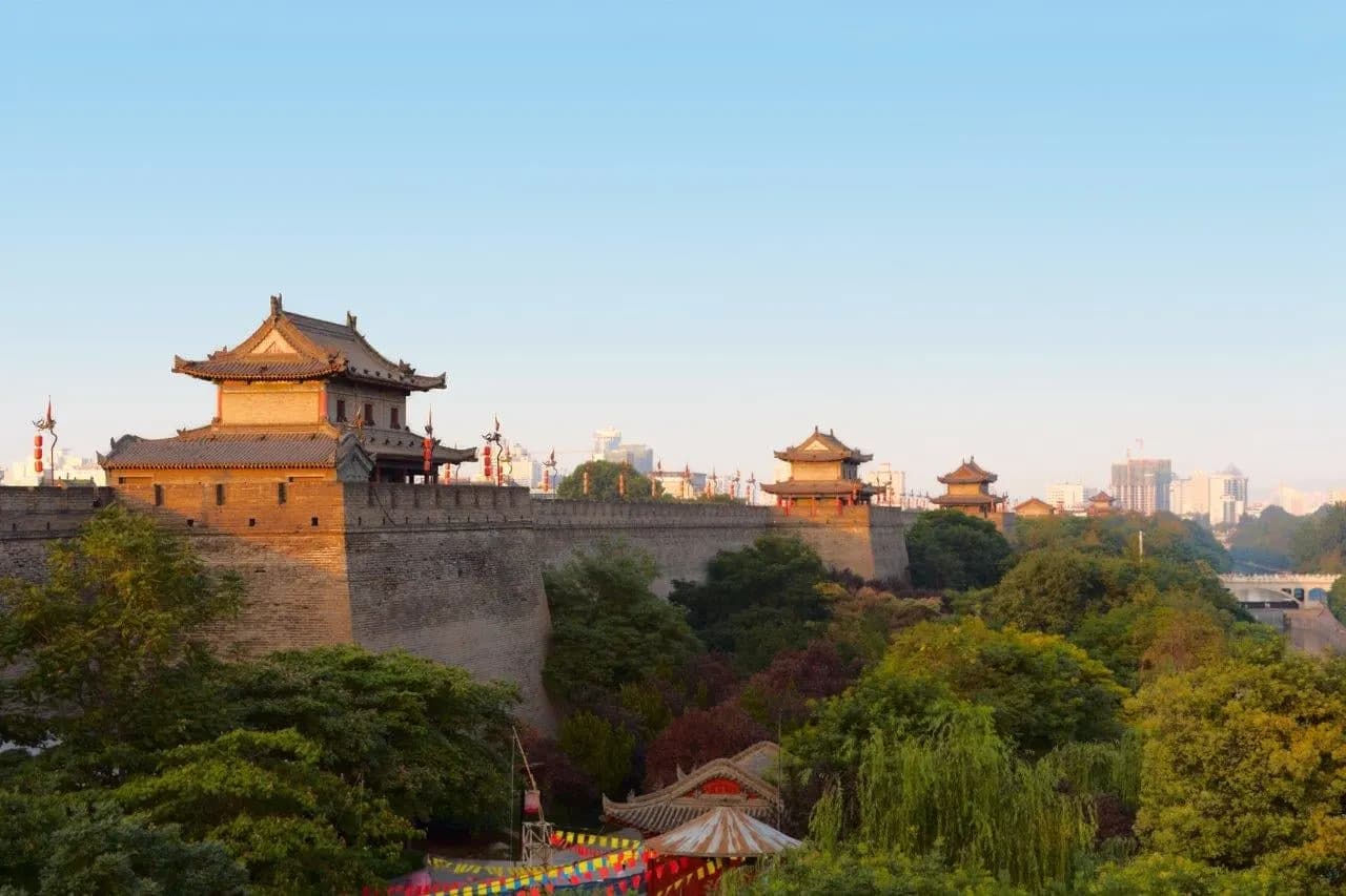 A gate tower on the old city wall in warm evening light above green trees