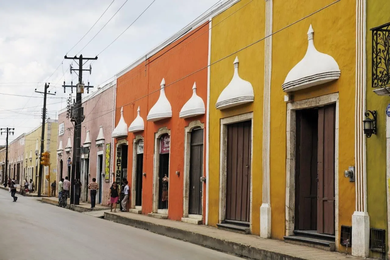 A street of ochre and orange colonial houses in a Yucatan town