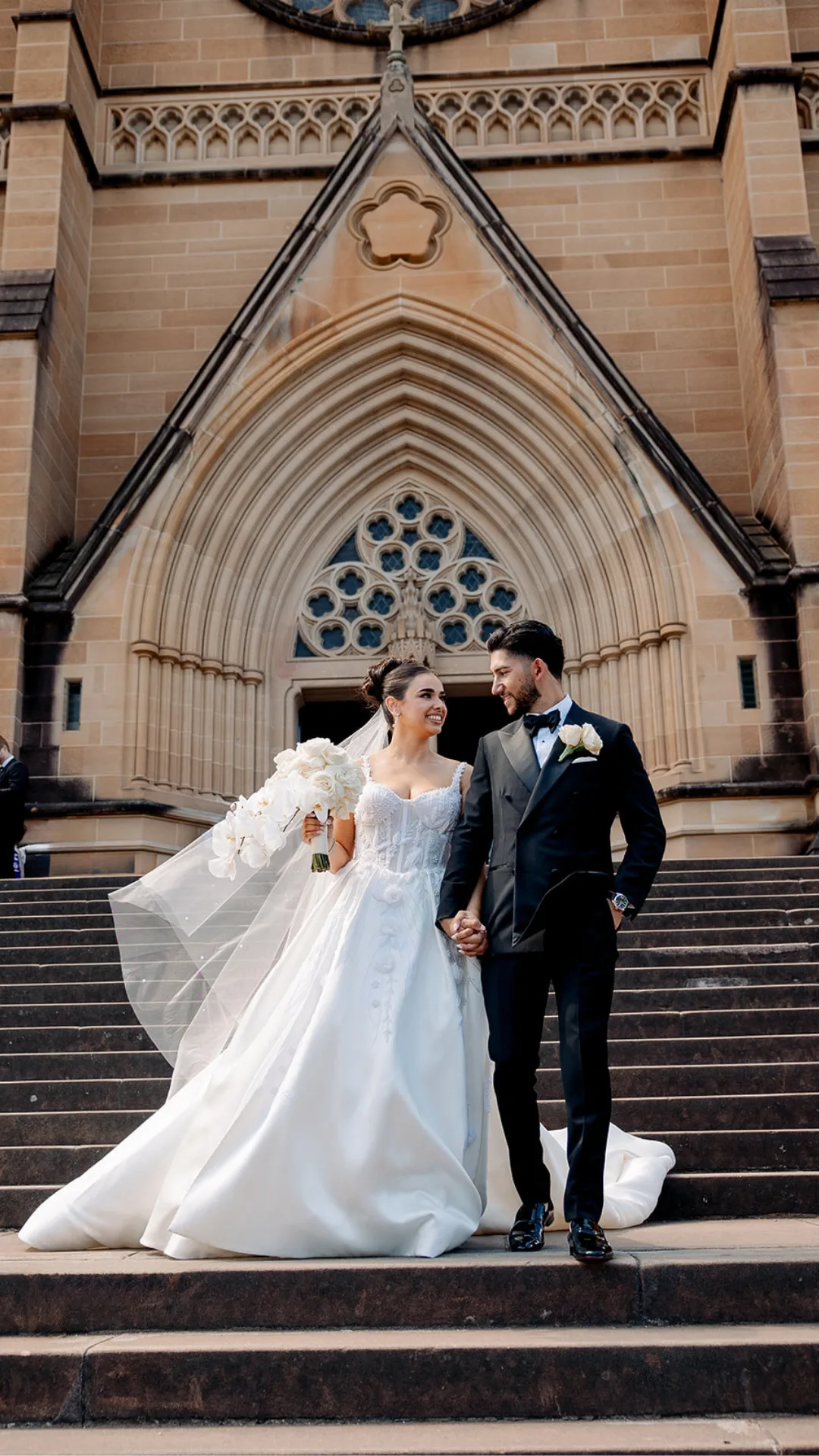 A couple on the steps of a cathedral after their ceremony