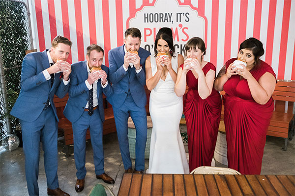 bridal party eating burgers in wedding clothes