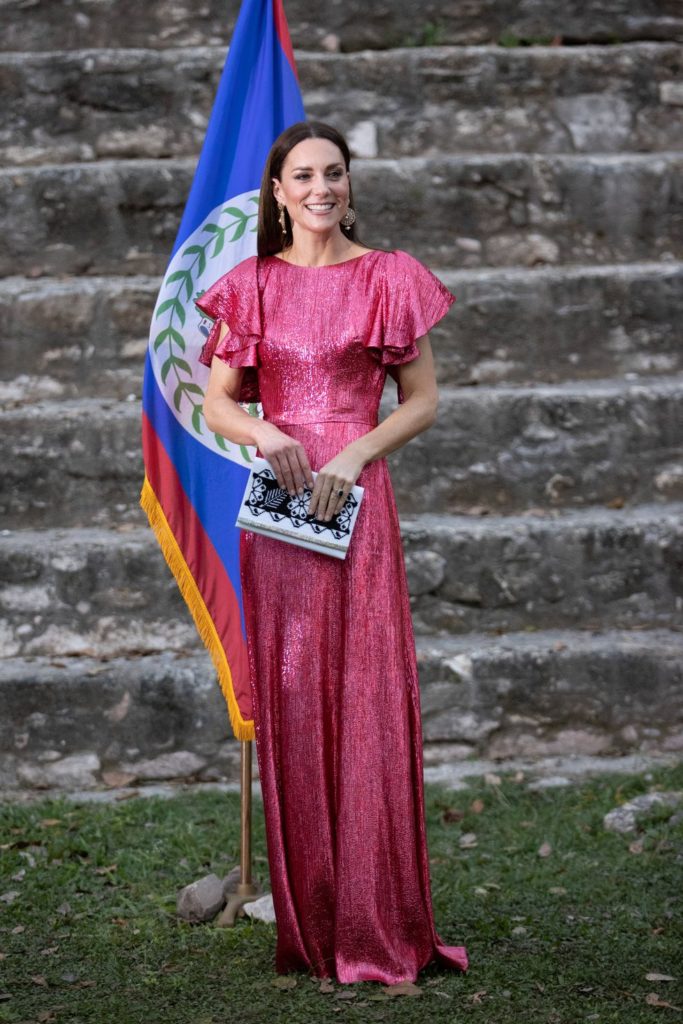 The Duchess in a pink sparkling dress with ruffled sleeves and a white clutch bag