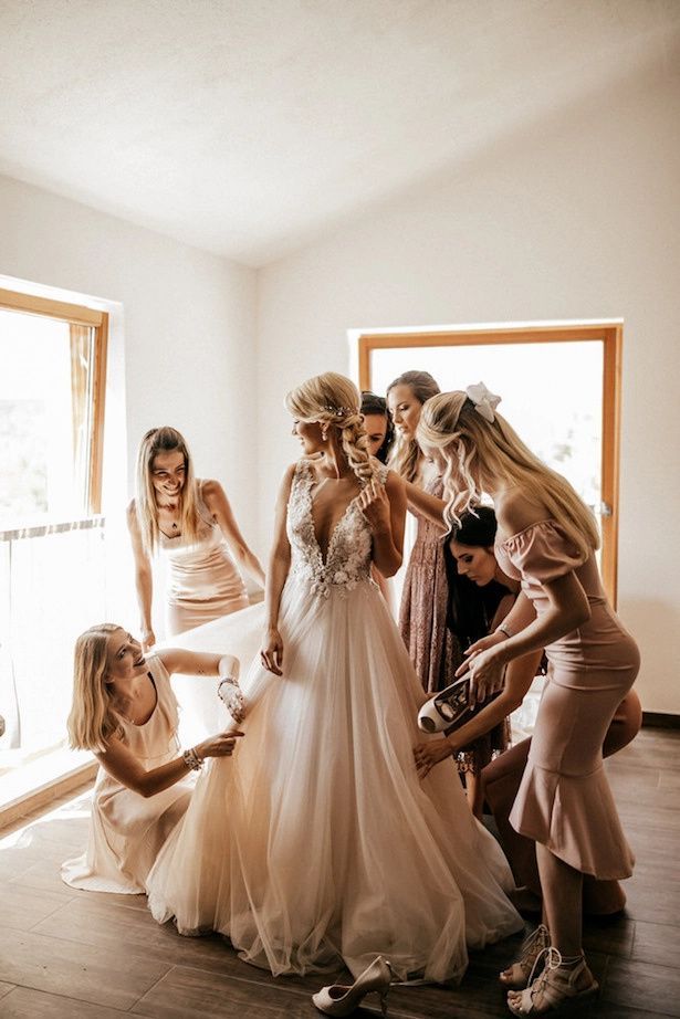 Bride with her stunning bridesmaid helping her with her dress and ensure the day is drama free