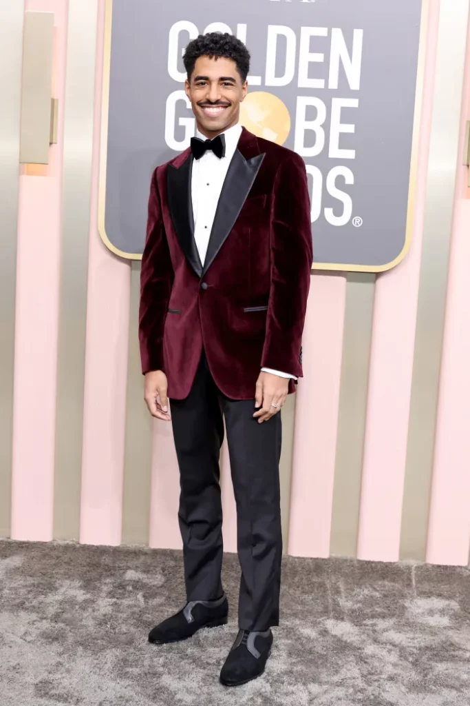 TikTok sensation Boman Martinez-Reid on the 2023 Golden Globes red carpet with a deep red velvet jacket