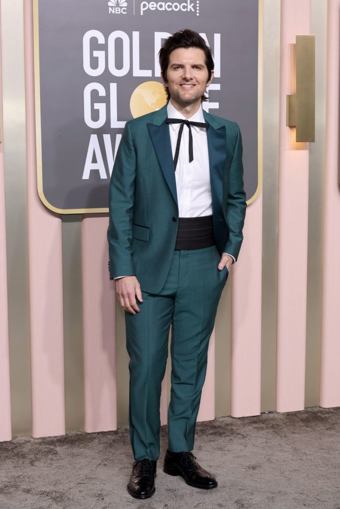 Adam Scott at the Golden Globes with his bold teal ensemble. The tailored Paul Smith suit in lush green wool-mohair features emerald lapels and a sleek black cummerbund with a thin black bow tie.