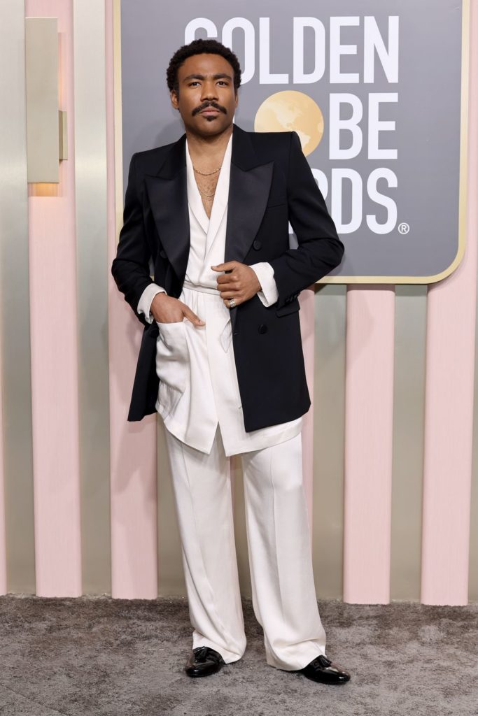 Donald Glover at the Golden Globes featuring a YSL tunic-style shirt jacket, oversized trousers, and black velvet tuxedo jacket
