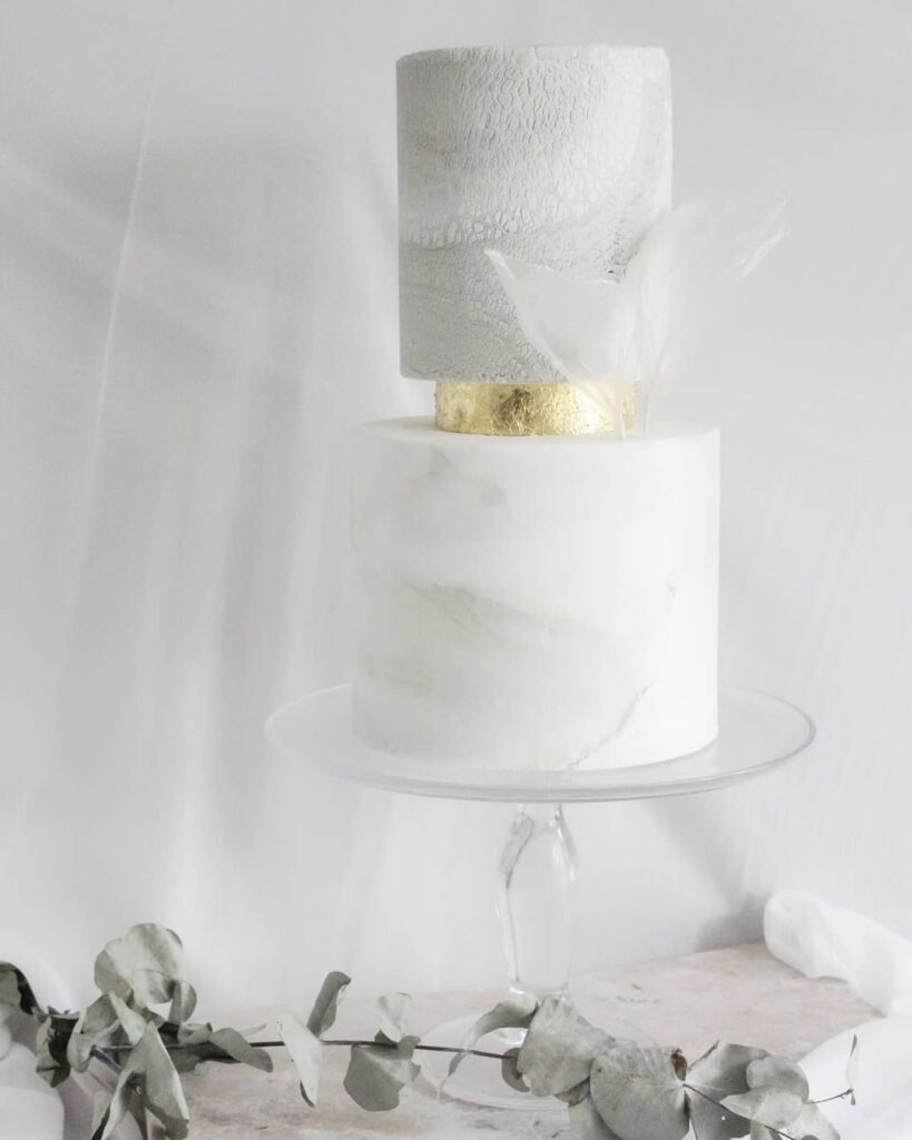 Minimalistic and modern take on the wedding cake with soft marbling and a metallic touch in the middle.