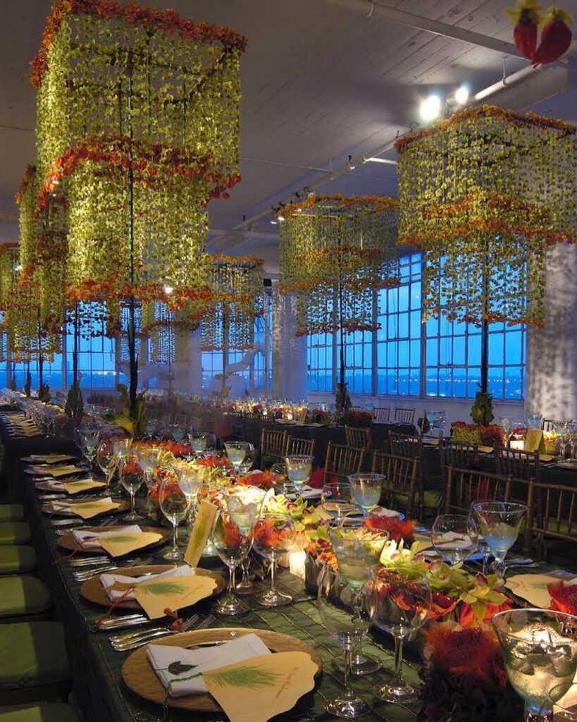 An orchid-filled wedding venue with pops of orange, green, and yellow.
