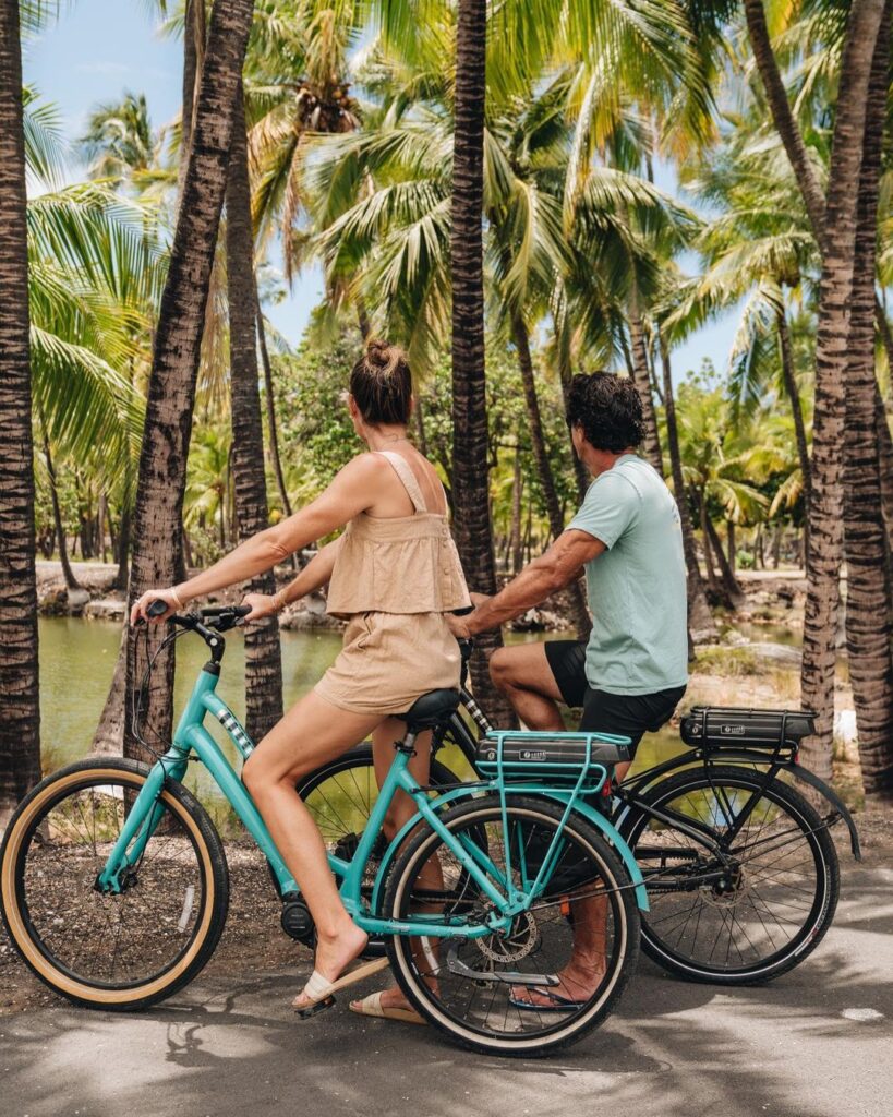 Couple biking through the expansive property of Mauna Lani Bay Hotel & Bungalows.