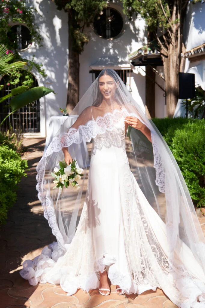 Stunning bride in her white veiled and chic wedding dress.