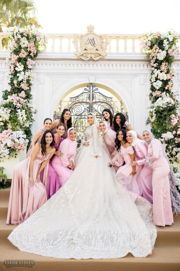 The stunning bride with her bridal party in different shades of pink bridesmaid dresses.