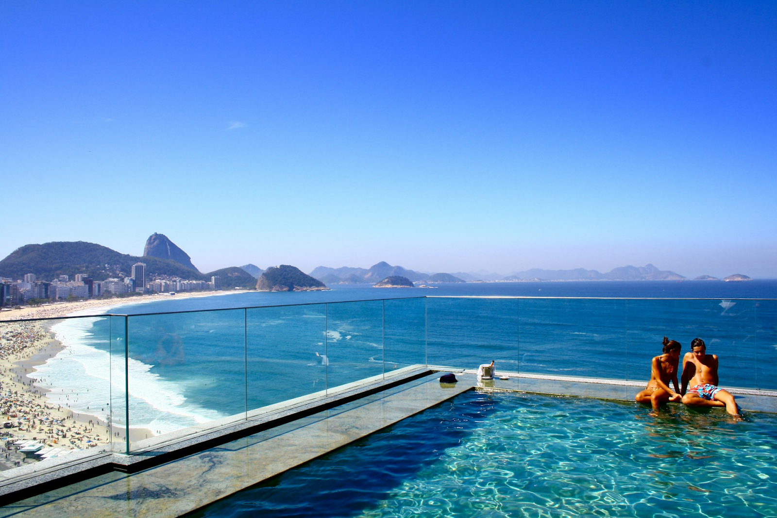 Honeymoon in Brazil - image of couple having conversation on infinity pool of a hotel beside beach