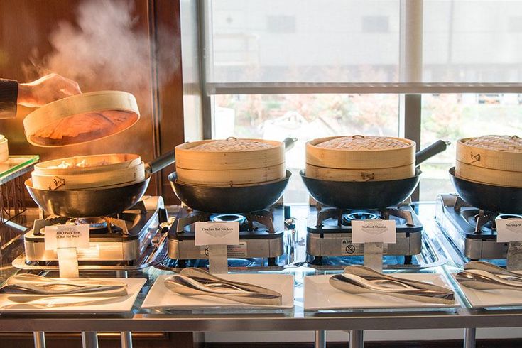 Steaming dim sum in bamboo baskets on a buffet table, showcasing Asian culinary traditions for weddings and events.