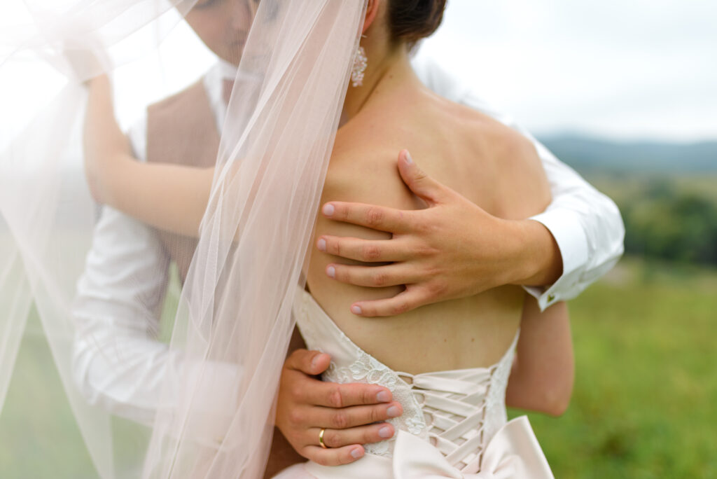 the bride and groom are hugging under the veil 2024 10 11 20 54 49 utc