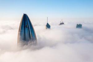 Kuwait City skyline emerging above the fog, showcasing modern architecture and skyscrapers, relevant to destination weddings in the Middle East.