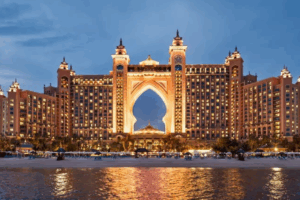 Atlantis The Palm resort in Dubai illuminated at dusk, showcasing its iconic architecture and beachfront setting, relevant for couples considering Middle Eastern destination weddings.