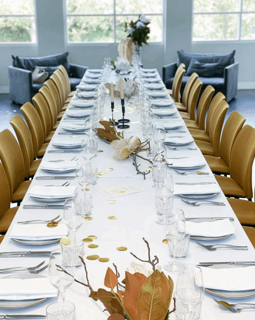 100 Breathtaking and Exclusive Australian Wedding Venues on every Couples Wish List! 32 Elegant dining setup at Hotel Centennial featuring a long table adorned with gold accents, crystal glassware, and contemporary decor, perfect for intimate weddings and events.