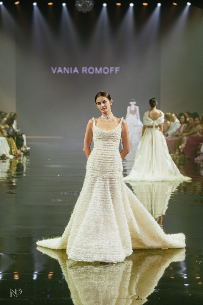 The World Has Been GIDEONIZED With A Bridal Fashion Extravaganza In The Philippines: Marry Me At Marriott X Gideon Hermosa 10 Model showcasing a romantic minimalism bridal gown by Vania Romoff on the runway during the Philippine Gratus Gala, with spotlight and elegant audience in the background.
