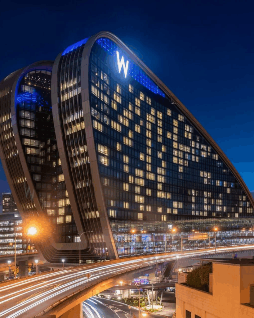 100 Breathtaking and Exclusive Australian Wedding Venues on every Couples Wish List! 52 W Sydney hotel at night, showcasing its modern architecture, illuminated ‘W’ sign, and vibrant cityscape, representing a premier wedding venue in Darling Harbour.