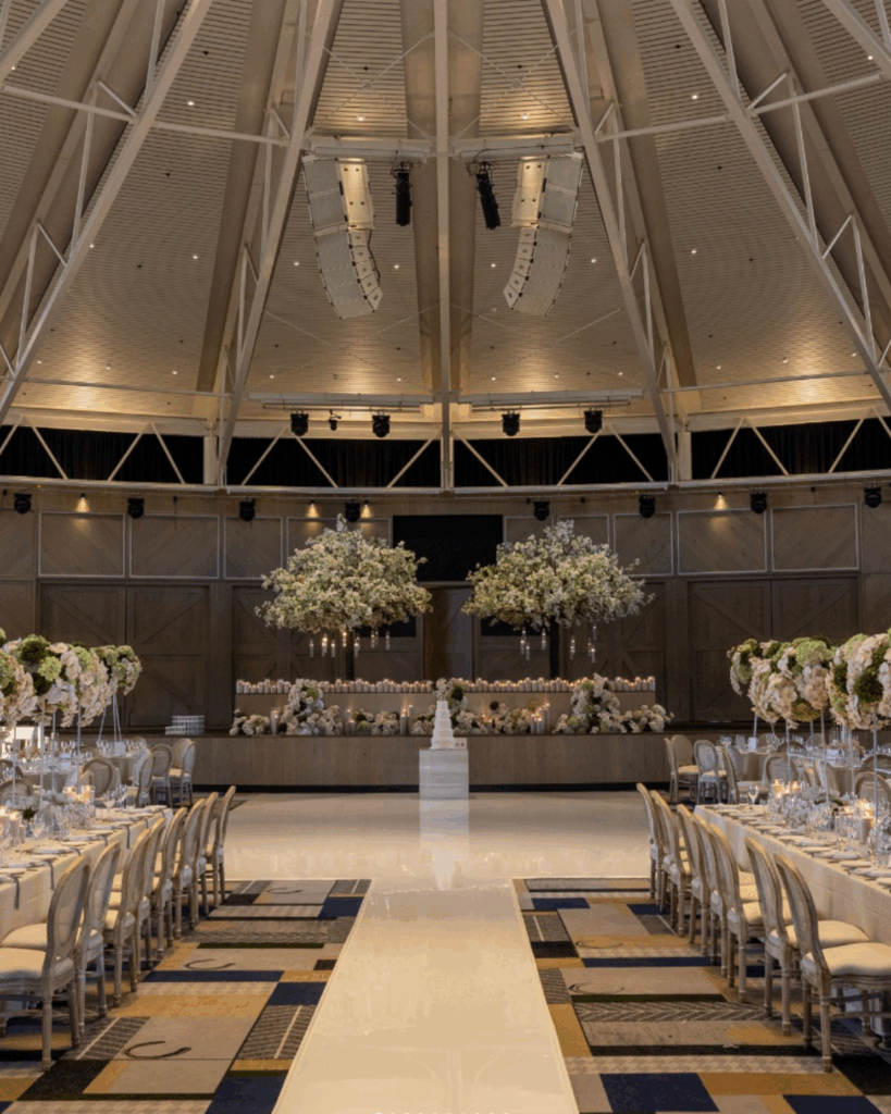 100 Breathtaking and Exclusive Australian Wedding Venues on every Couples Wish List! 53 Elegant wedding venue setup at the William Inglis Hotel featuring a spacious interior with floral arrangements, a central cake display, and tables set for guests, ideal for large celebrations.